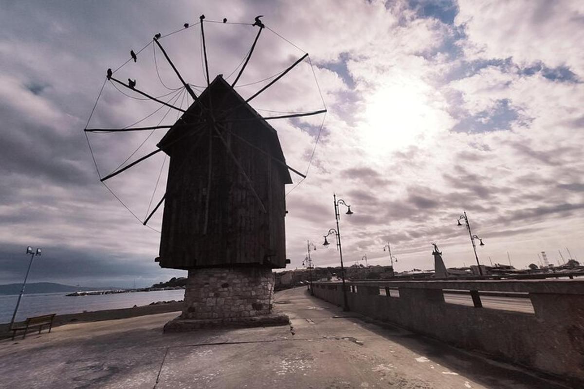 a stone windmill on the side of a beach