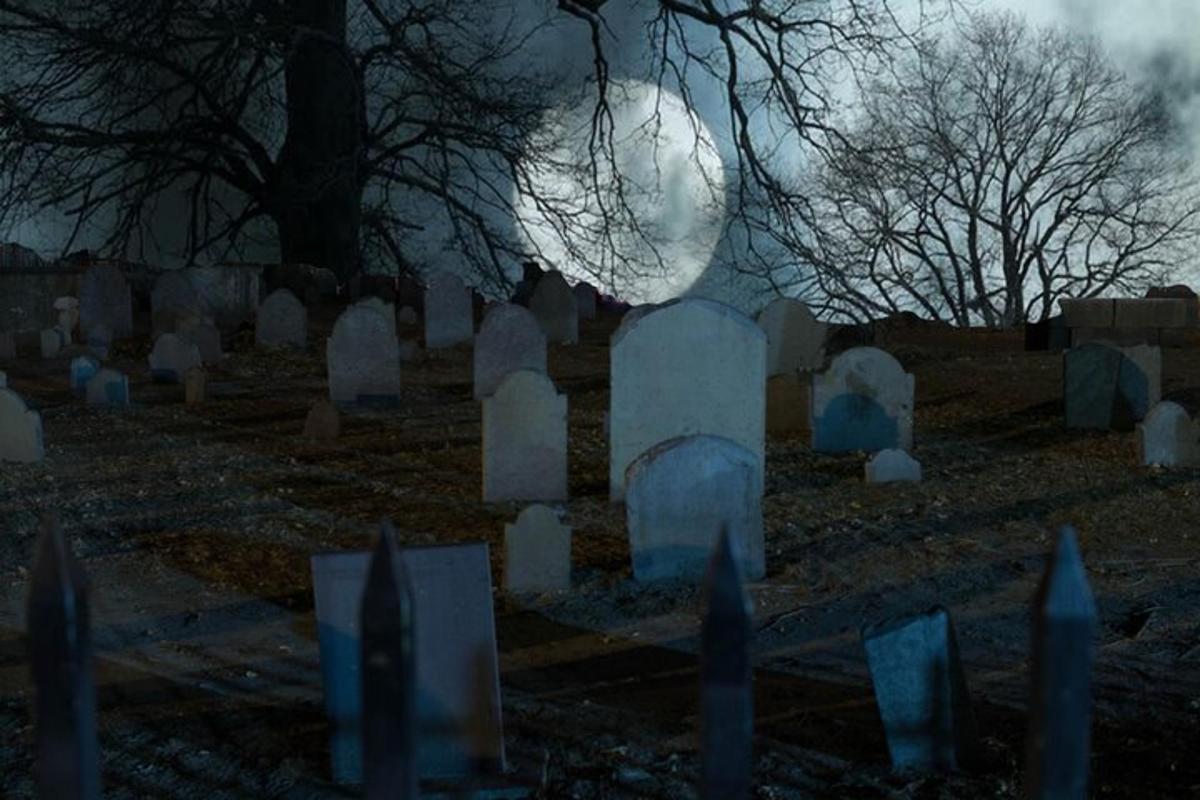 un cimitir cu lună plină în fundal