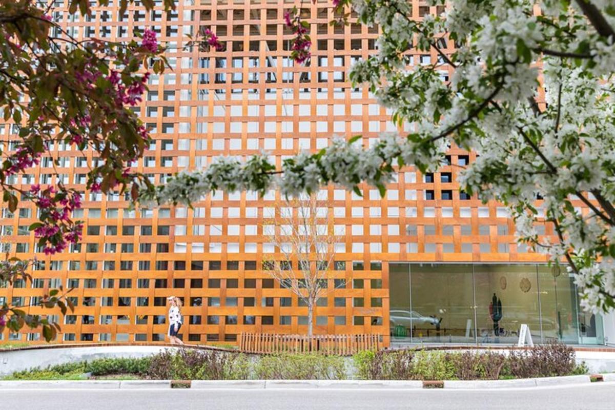 a tall orange building with a tree in front of it