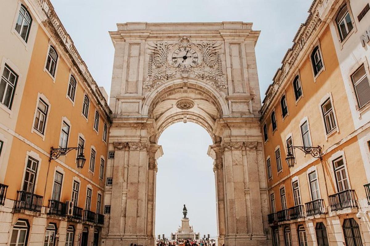 an arch with a clock in the middle of two buildings