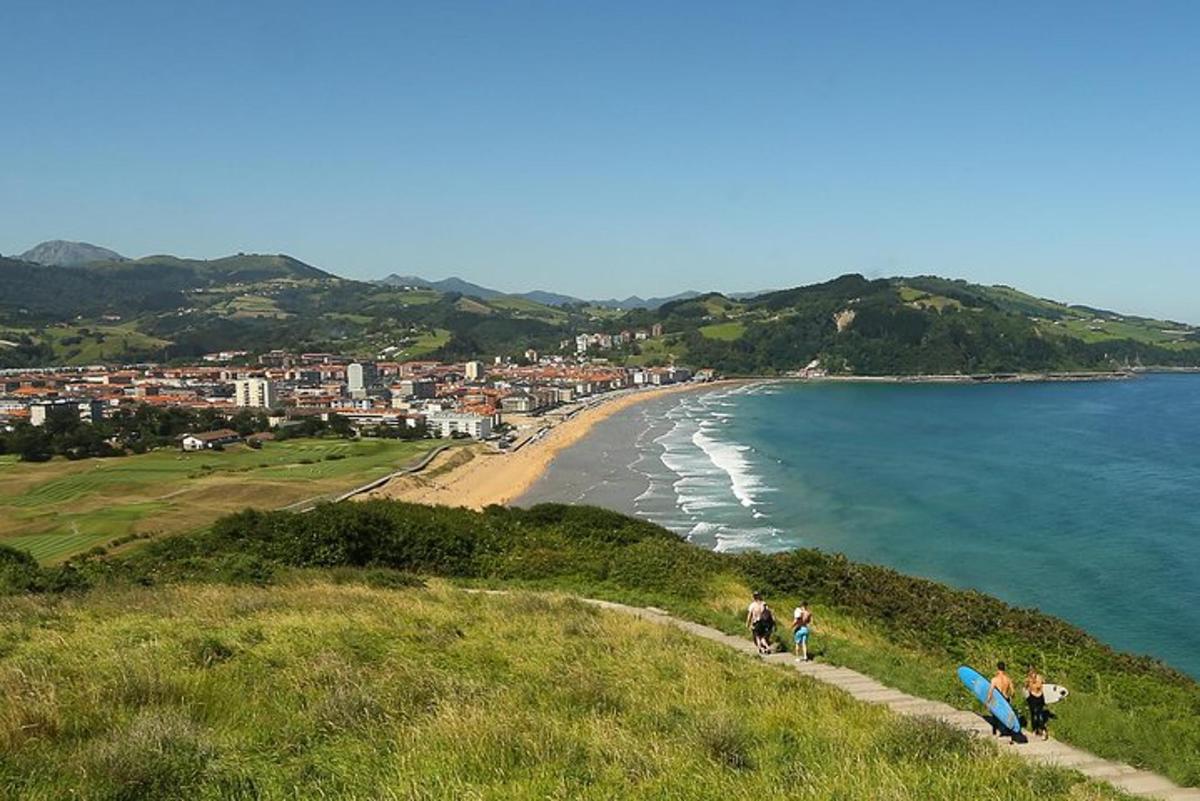 skupina ljudi, ki hodi po hribu ob plaži