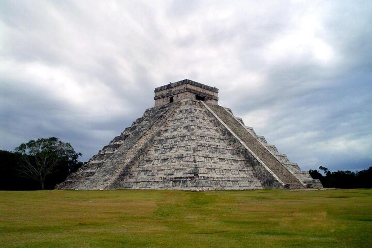 en pyramide i et felt med en overskyet himmel
