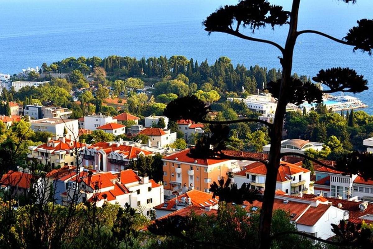 pohľad na mesto s oranžovými strechami a oceán