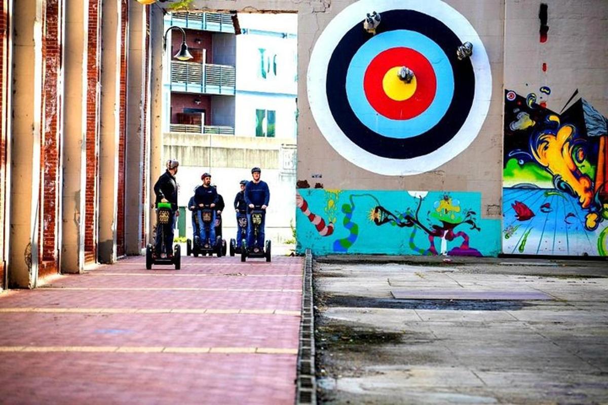 three men on scooters in front of a wall with a target