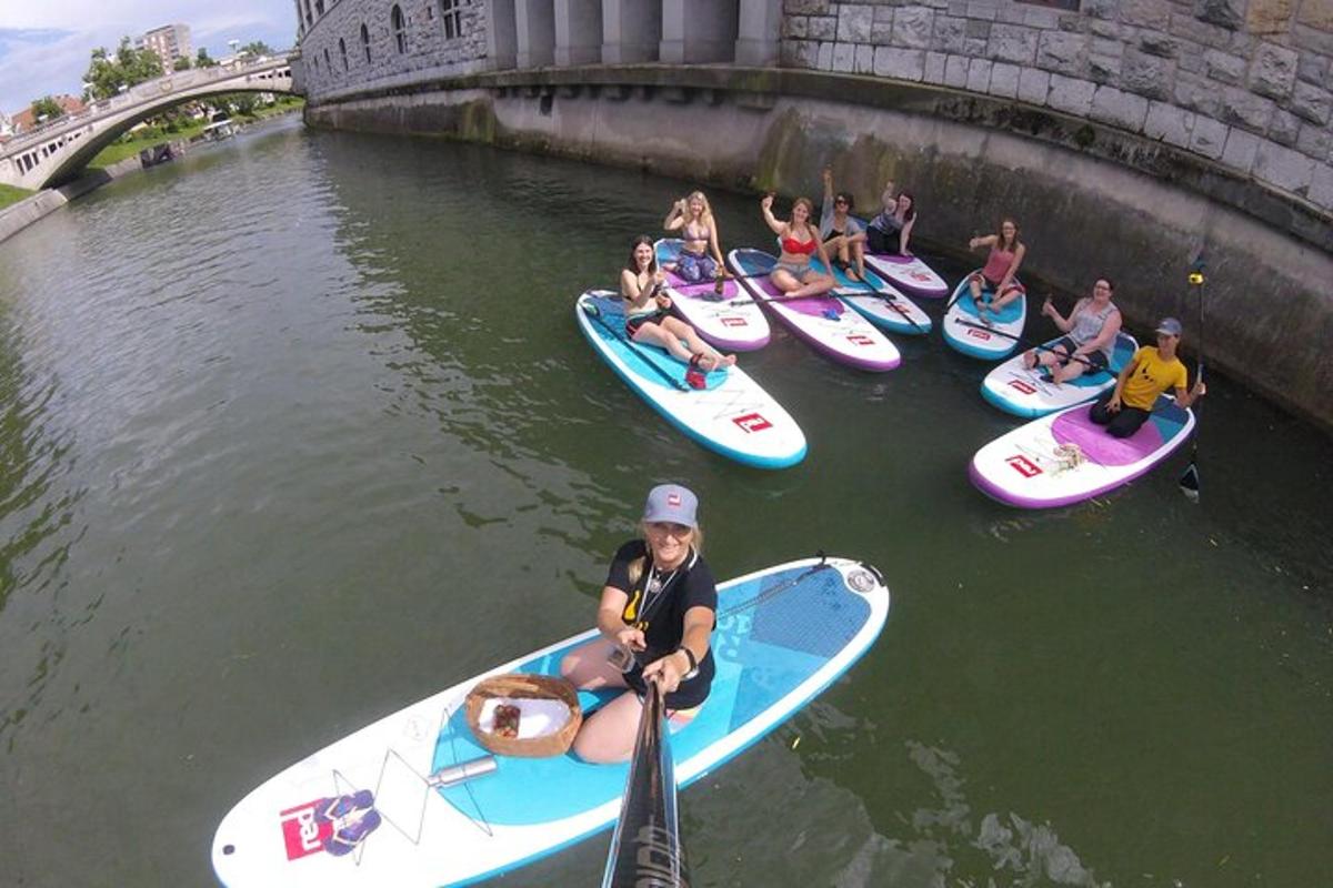 un grup de oameni pe plăci de paddle în apă