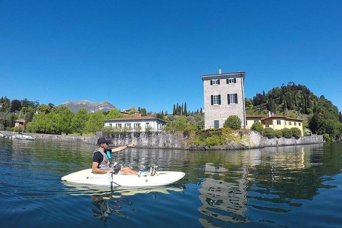 una persona asseguda en una taula de paddle surf a l'aigua