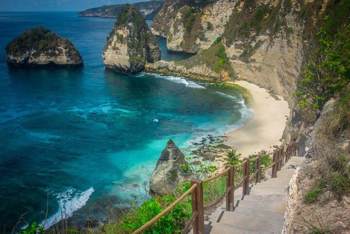 a path to a beach with rocks in the ocean