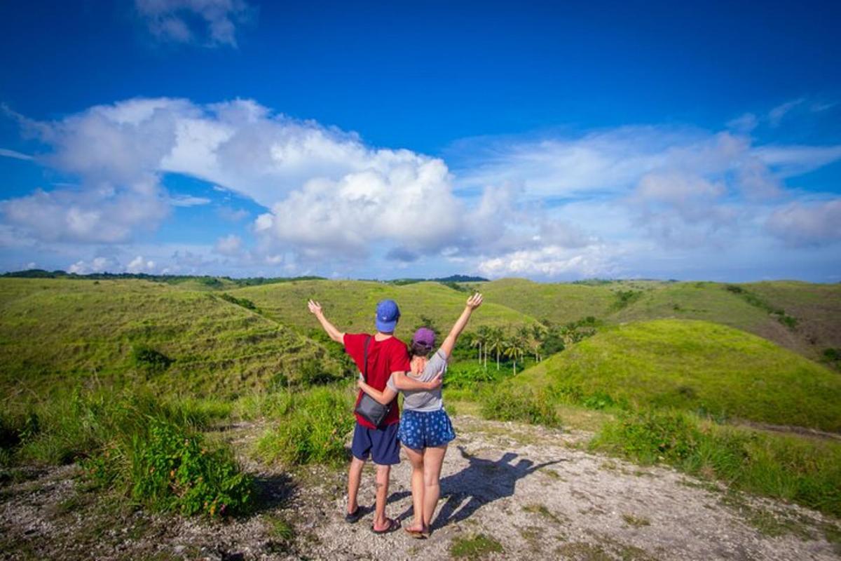 two people standing on top of a hill with their arms up