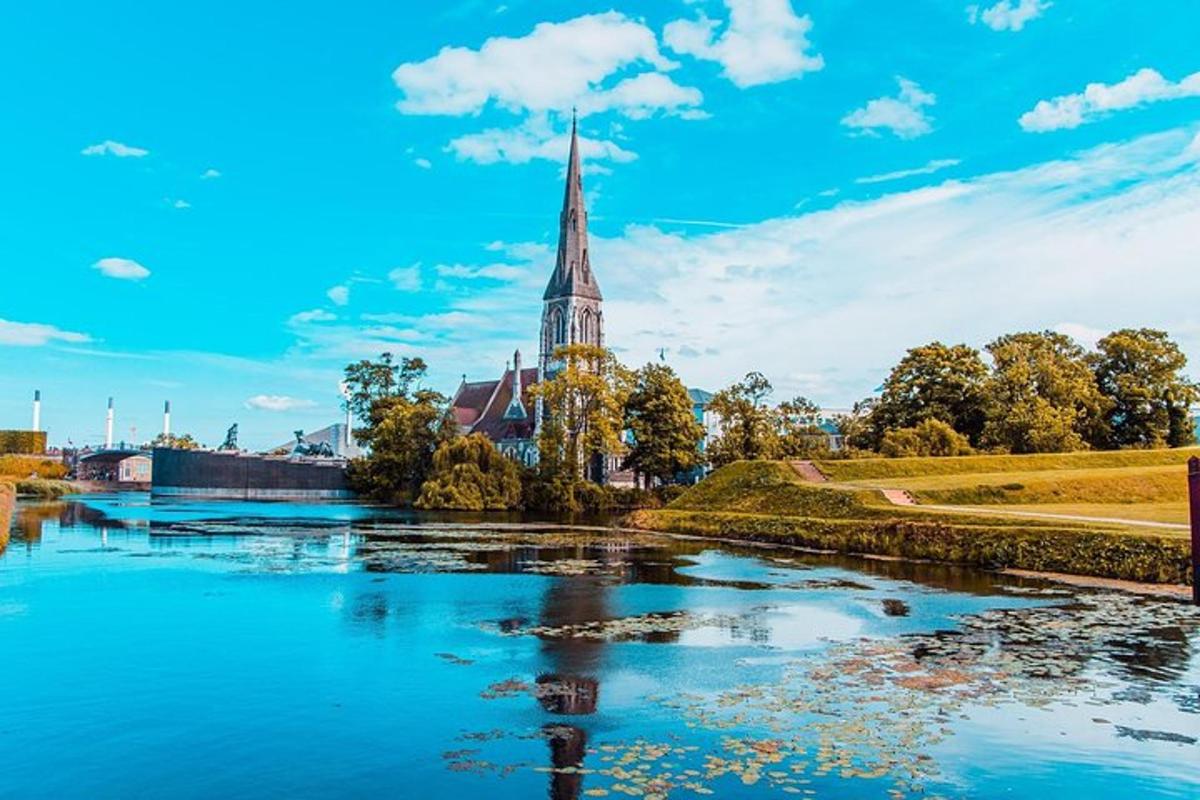uma igreja com um campanário próximo a um rio