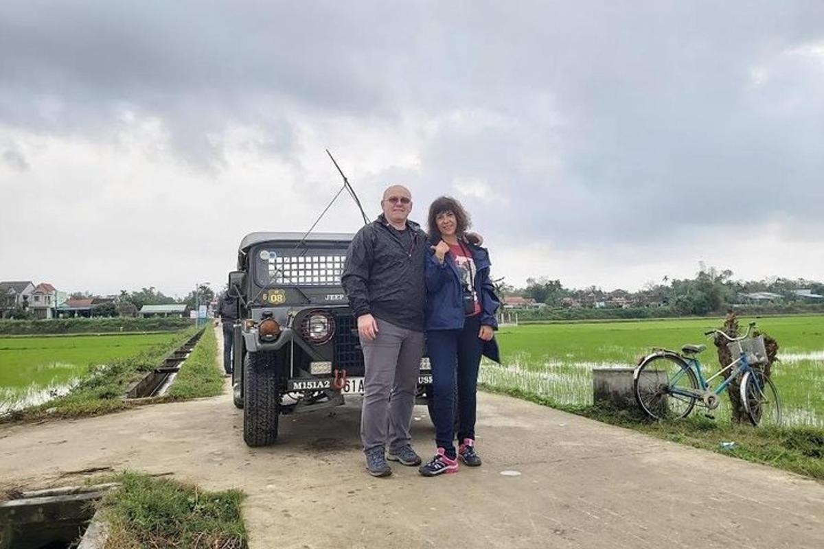 seorang lelaki dan seorang wanita berdiri di hadapan sebuah jip