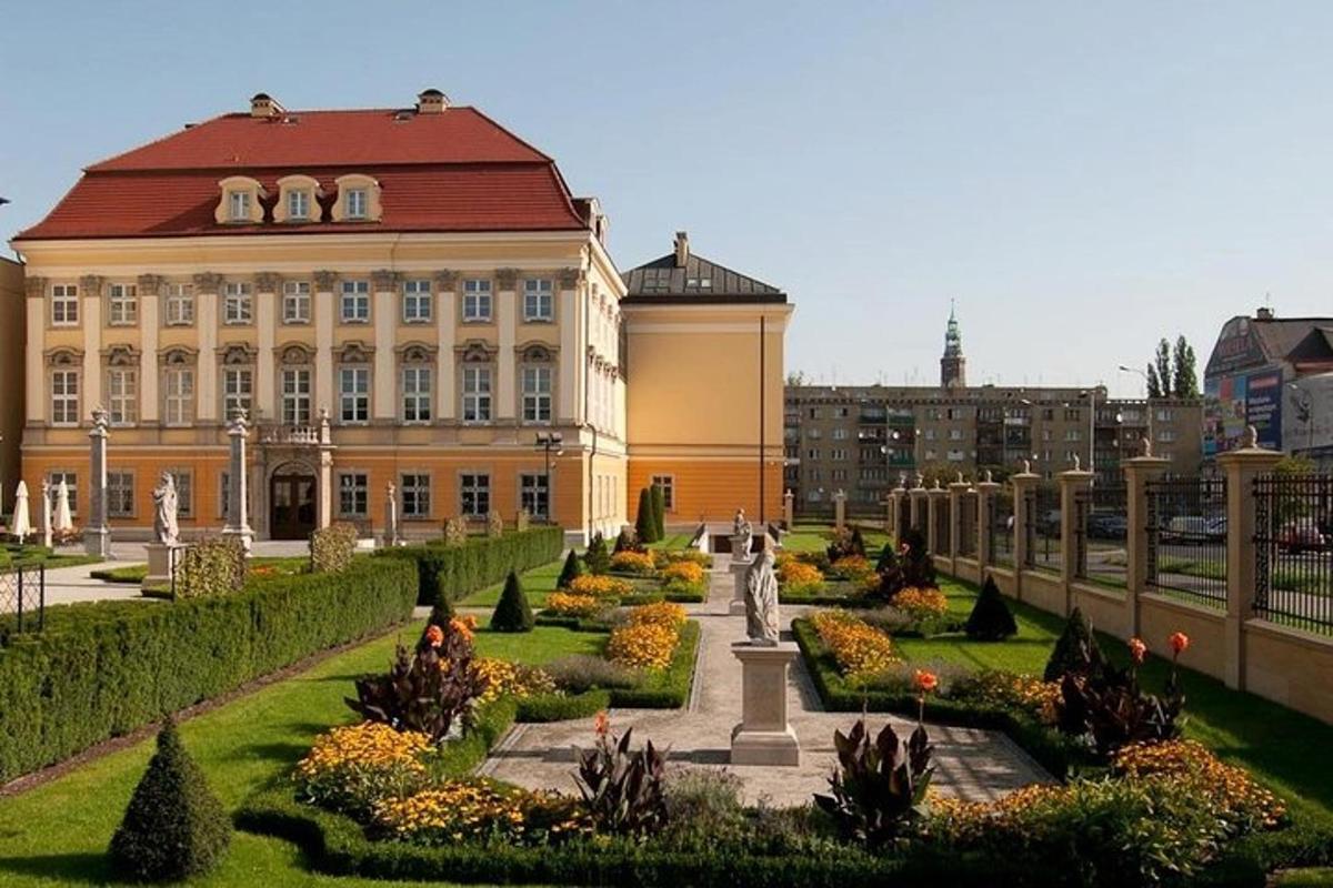 un grande edificio con un giardino antistante