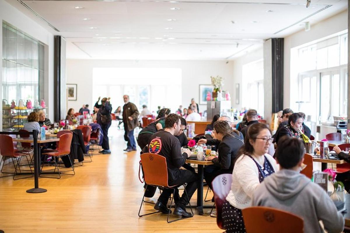 een groep mensen die aan tafels in een restaurant zitten