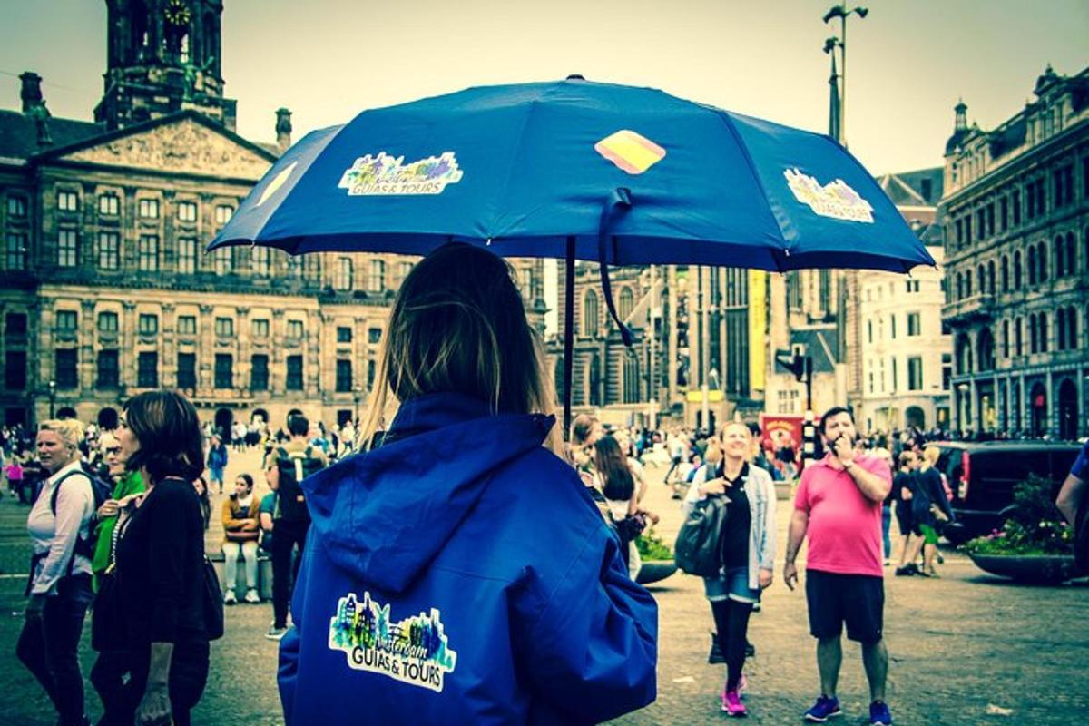 um grupo de pessoas caminhando pela rua com um guarda-chuva azul