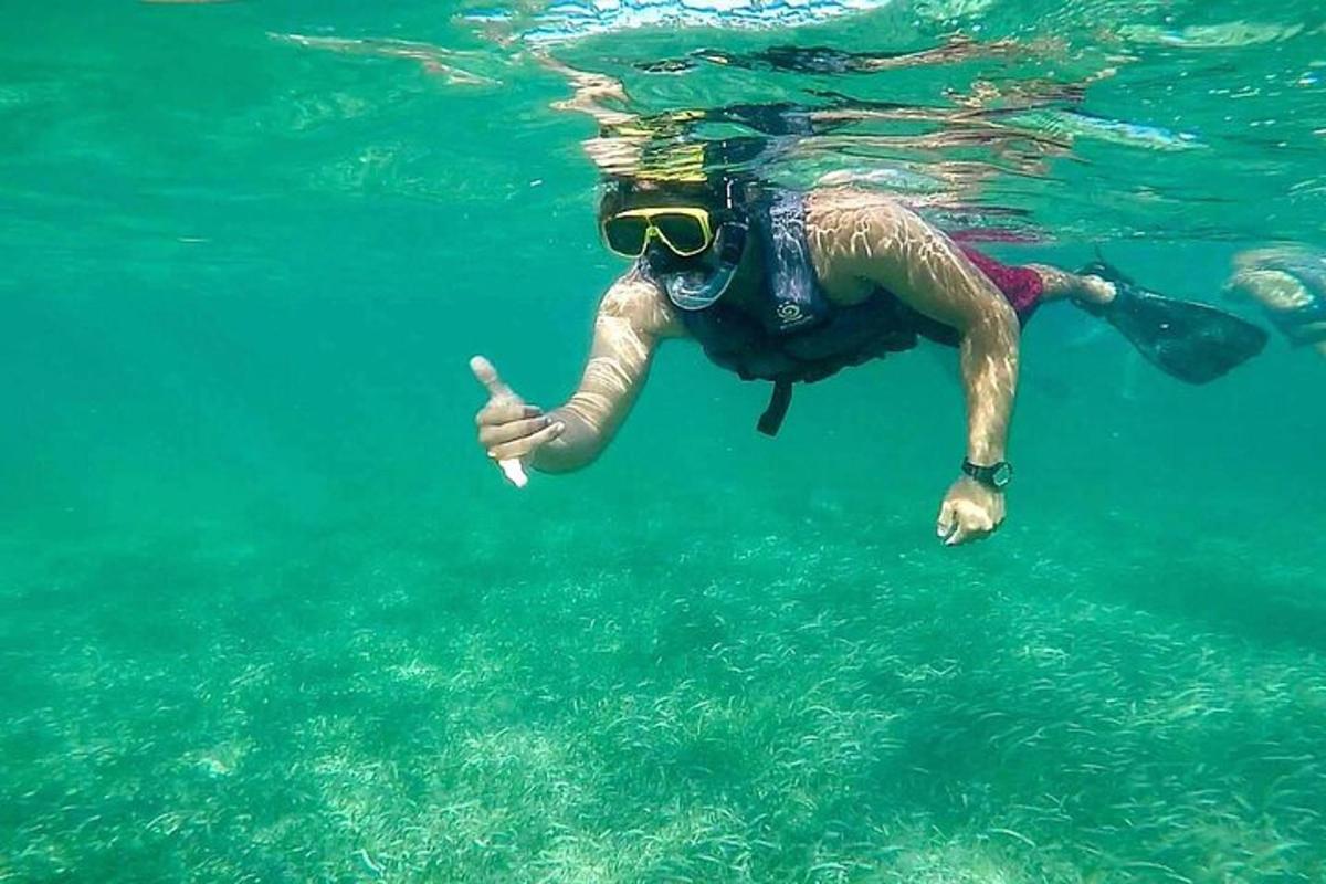 ein Mann mit Sonnenbrille schwimmt im Wasser