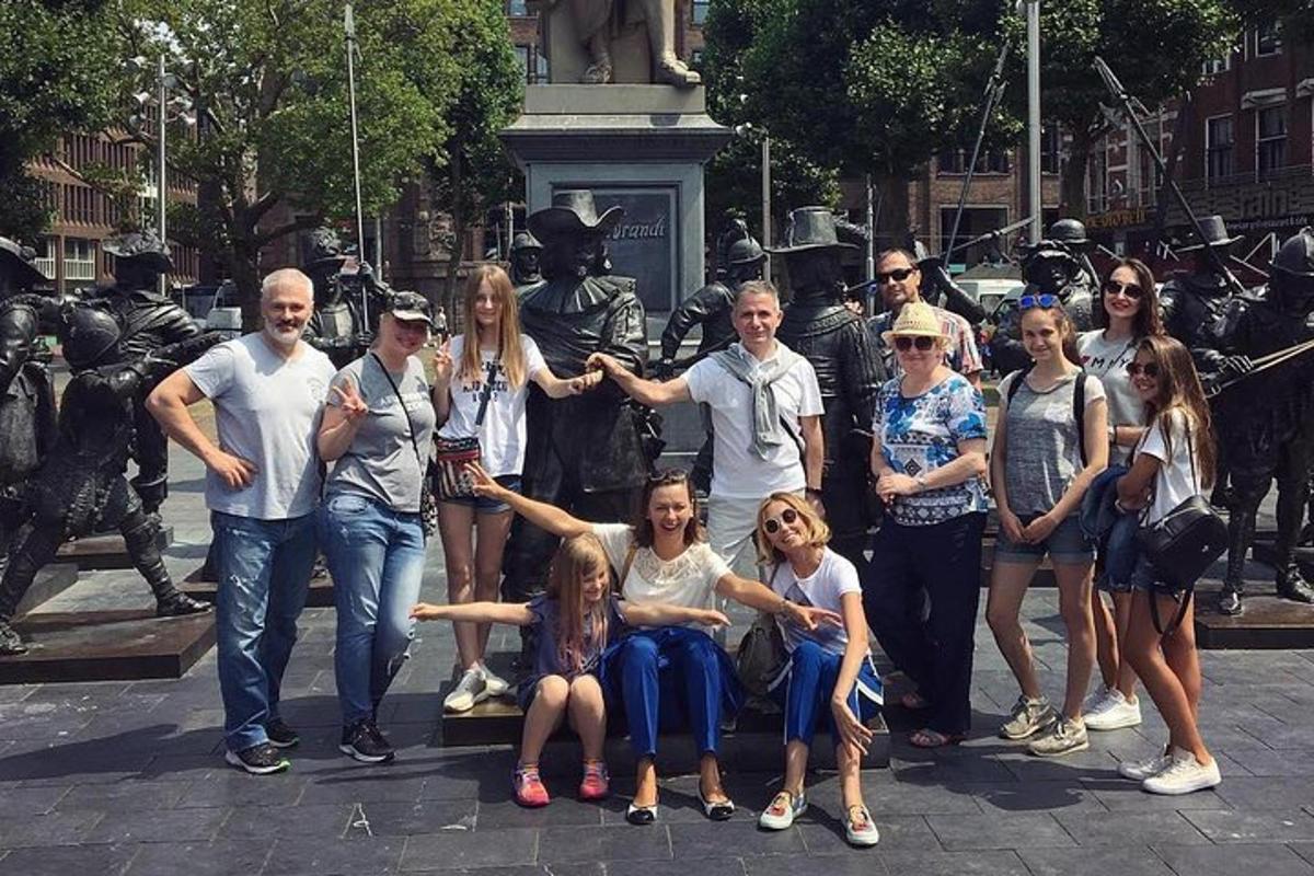 un grup de persones posant davant d'una estàtua