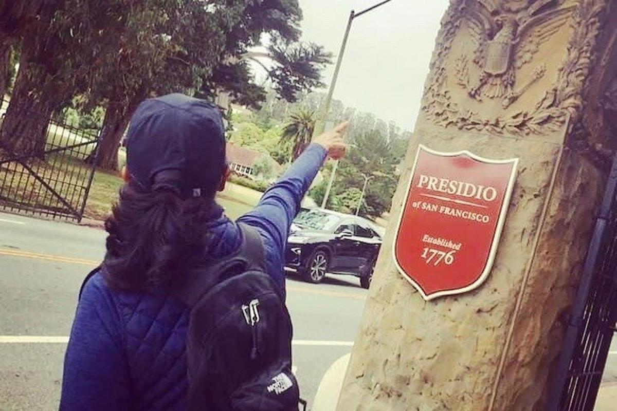 a person standing next to a sign on a tree
