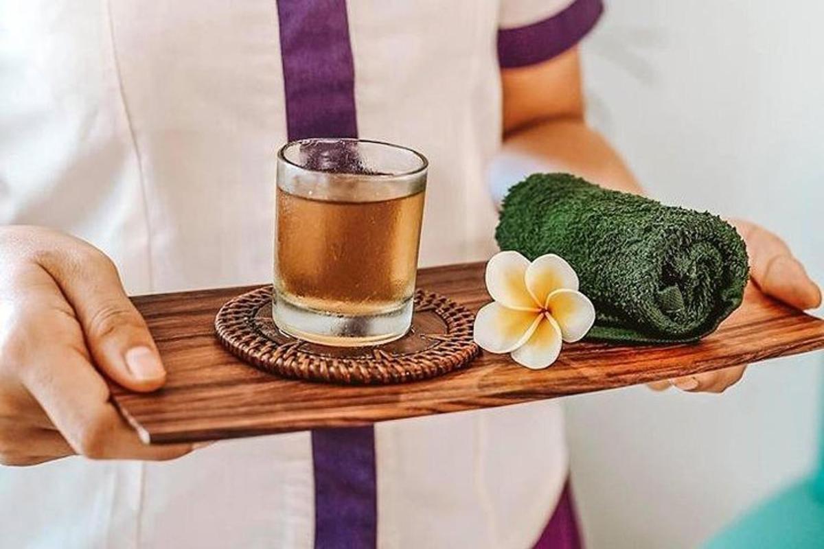 a person holding a tray with a drink and a flower