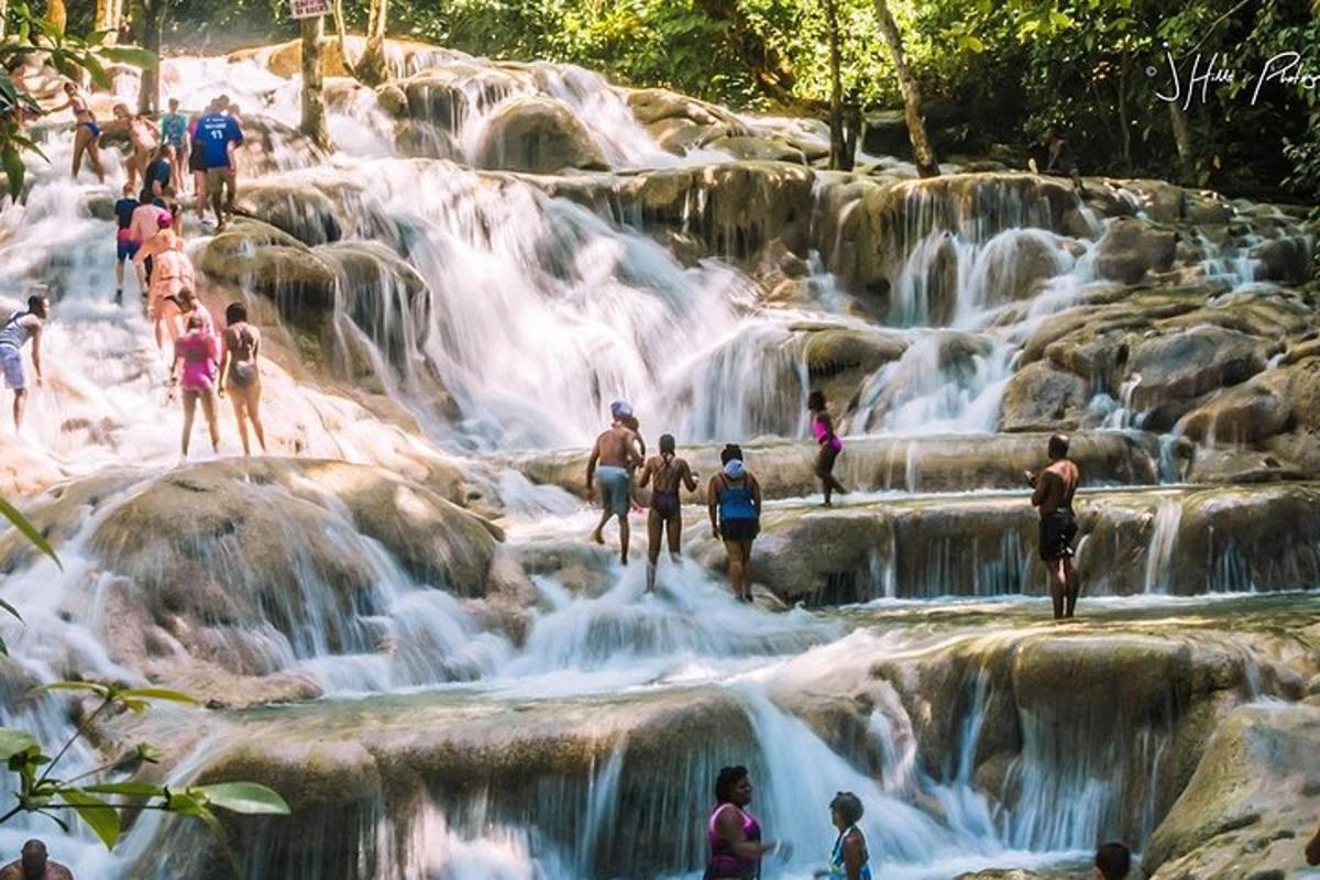 een groep mensen die op rotsen bij een waterval staan