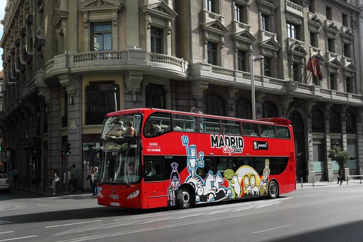 a red double decker bus driving down a city street