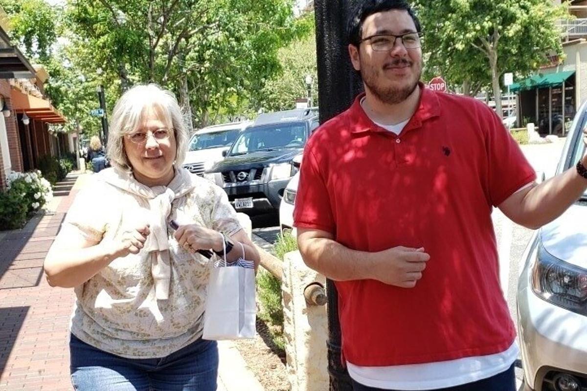 a man and a woman standing next to a car