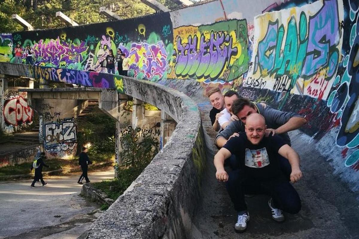 một nhóm người đang ngồi trên một bức tường có hình vẽ graffiti
