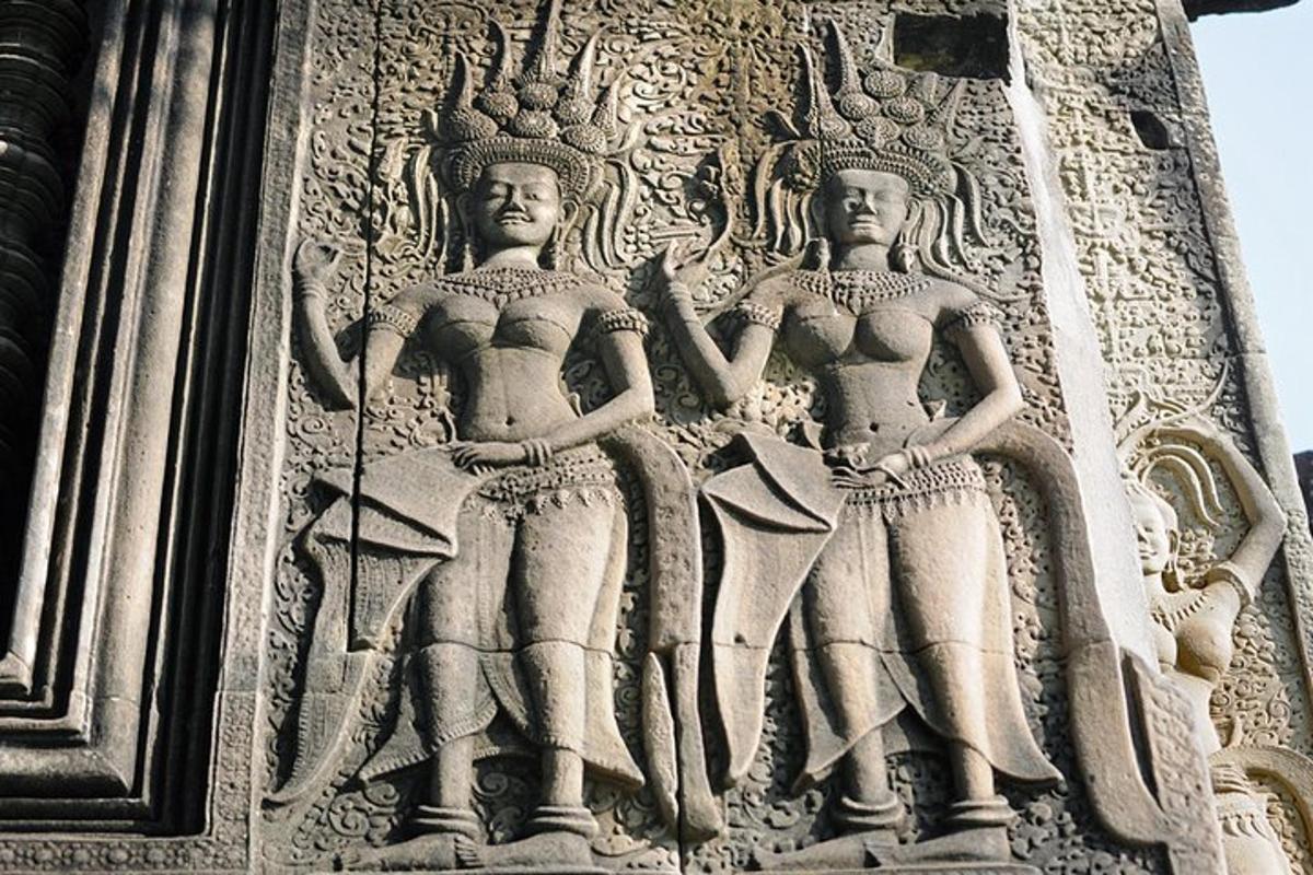 a stone sculpture of two women on the side of a building