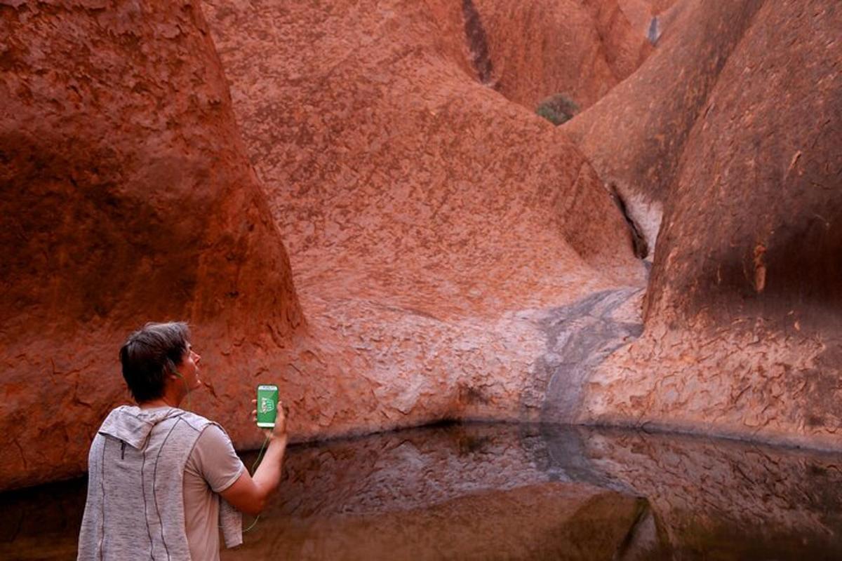 a man holding a cup in front of a canyon