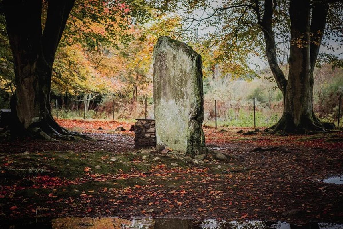a stone monument sitting in a field with trees