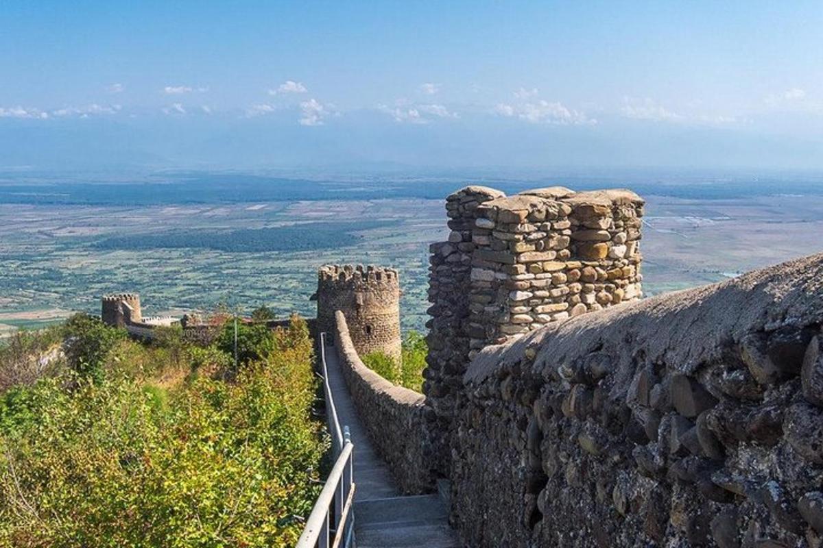 un muro di pietra con una passerella su una collina