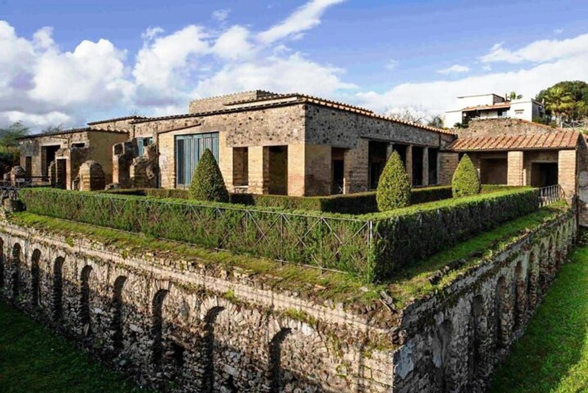 una casa con un muro di pietra e cespugli
