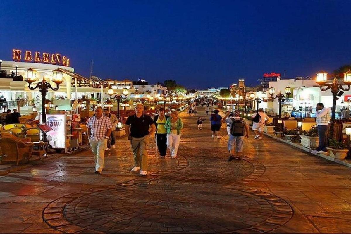 Un grupo de personas caminando por una calle de noche