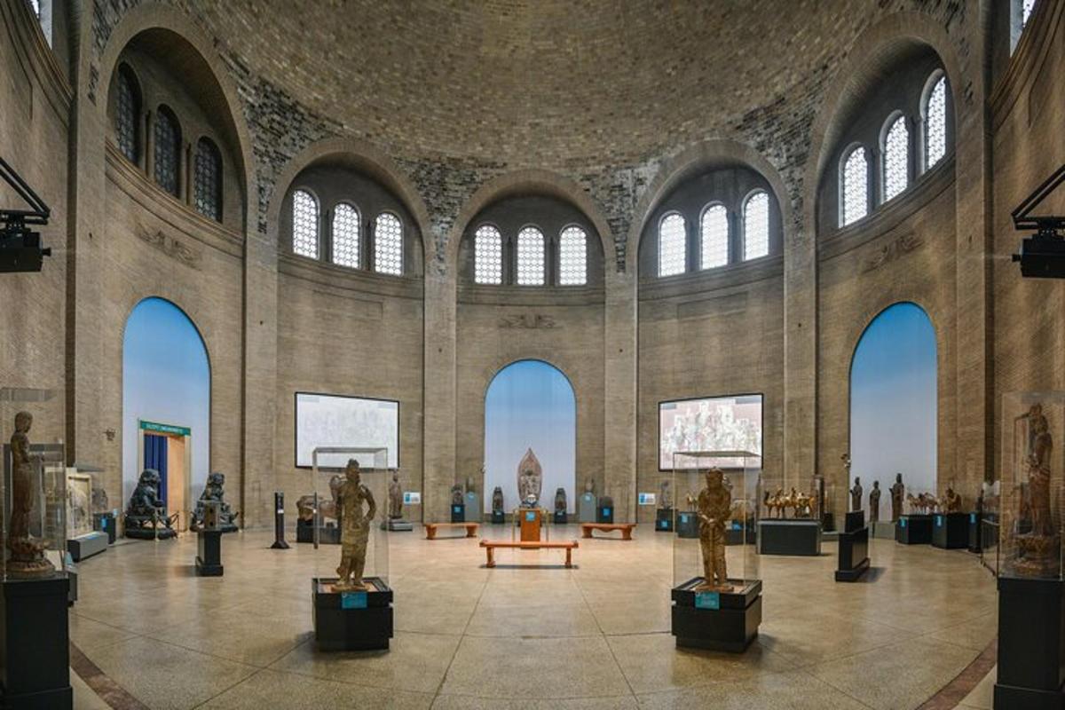 a museum with statues in a large room with windows