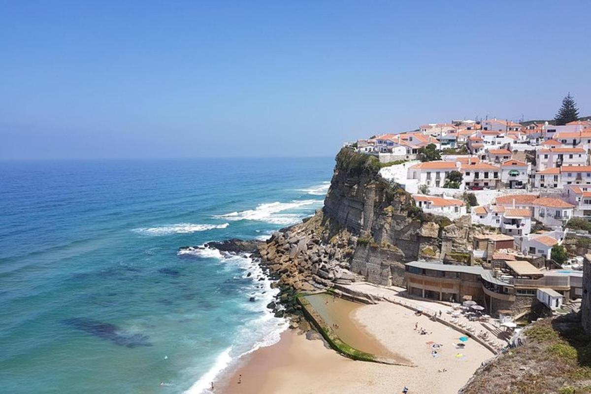 uma vista de uma praia com casas em um penhasco