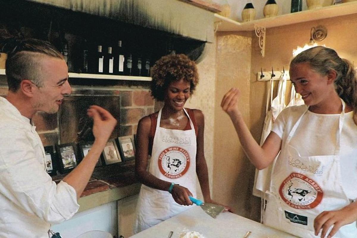 un uomo e due donne in una cucina che preparano il cibo
