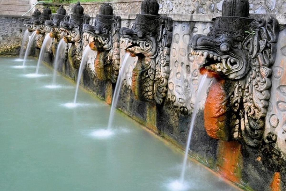 a row of water fountains on a stone wall