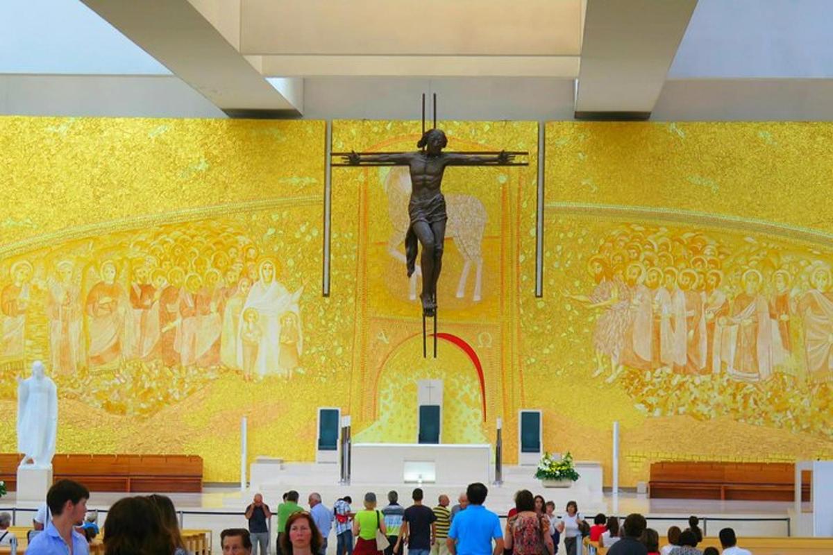 una folla di persone in piedi davanti a una statua di un crocifisso