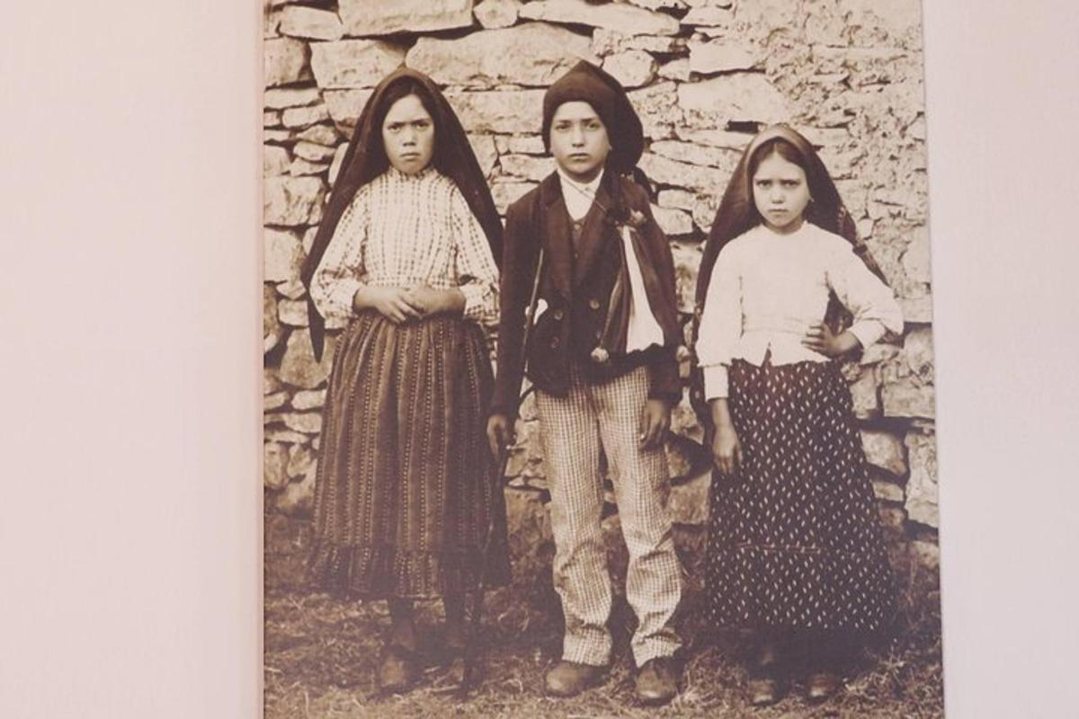 una vecchia foto di tre donne davanti a un muro di pietra