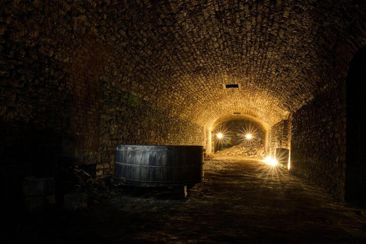 a dark tunnel with a barrel and lights in it