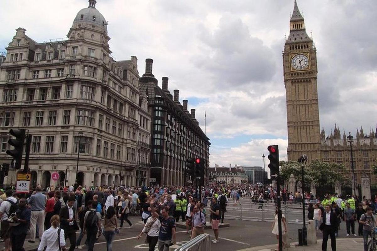 una folla di persone in una strada cittadina con il Big Ben