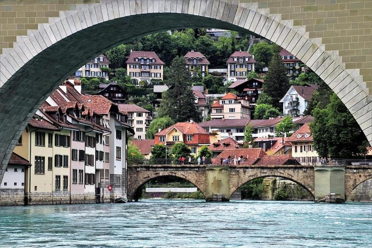 a bridge over a river with a city in the background