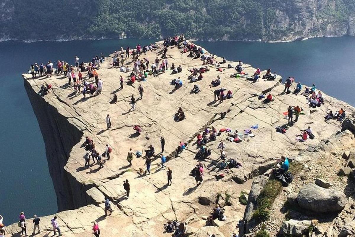 a large group of people on a cliff near the water