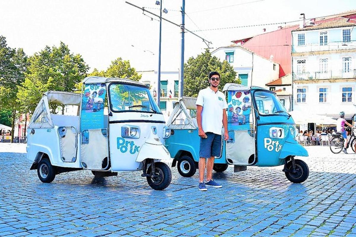 Čovjek stoji pored dva mala automobila