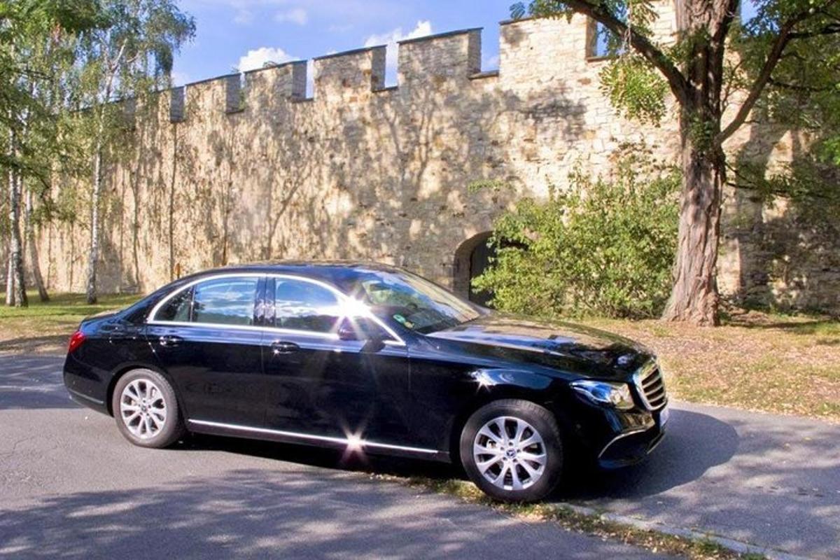 um carro preto estacionado em frente a um muro