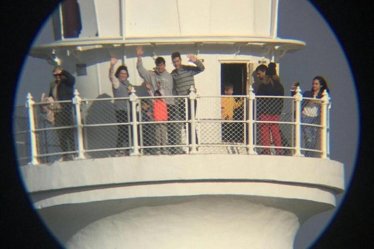 a group of people standing on top of a lighthouse