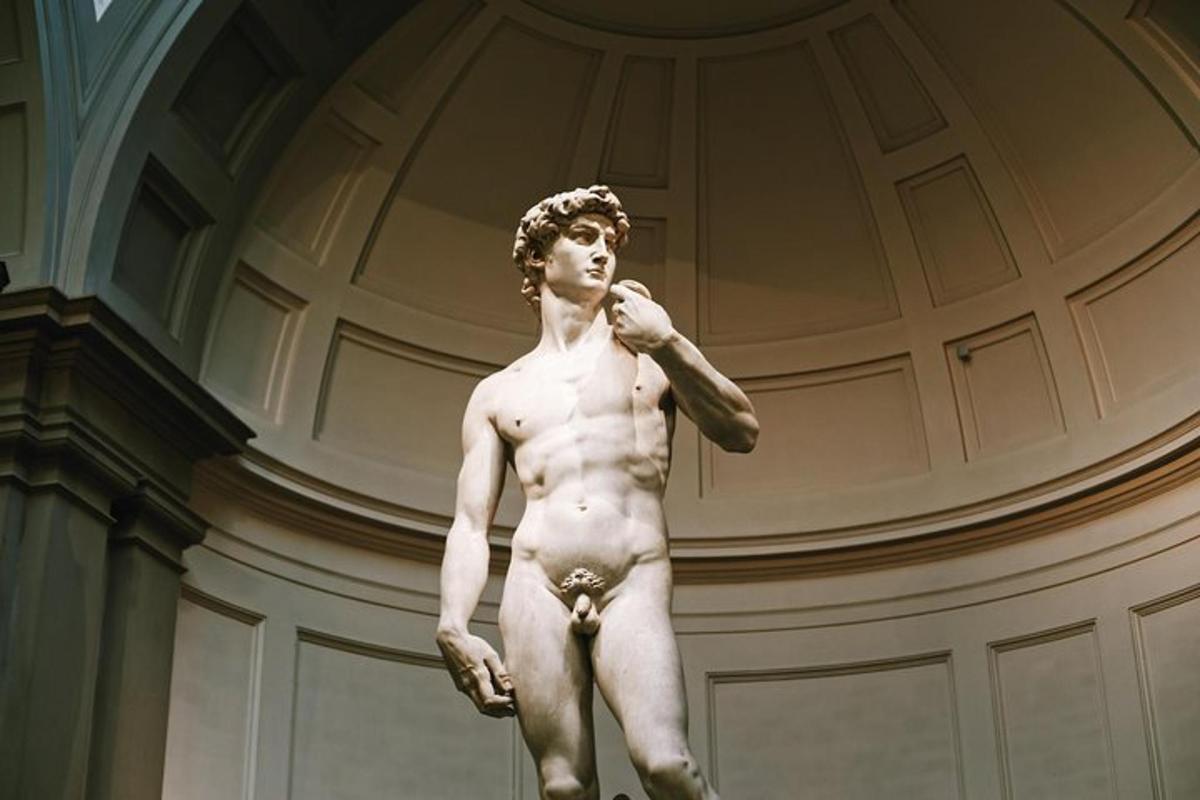 uma estátua de um homem sem camisa em pé em um prédio