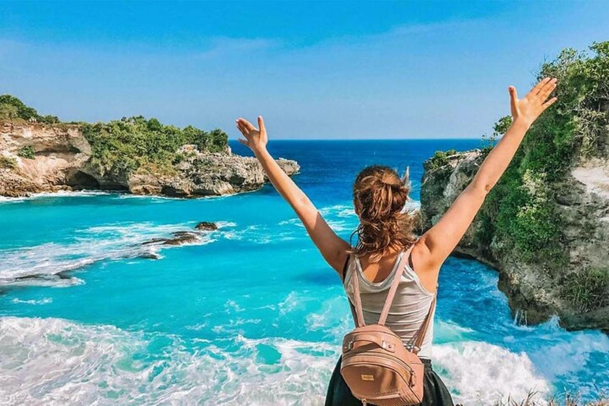 a woman standing on a cliff looking at the ocean