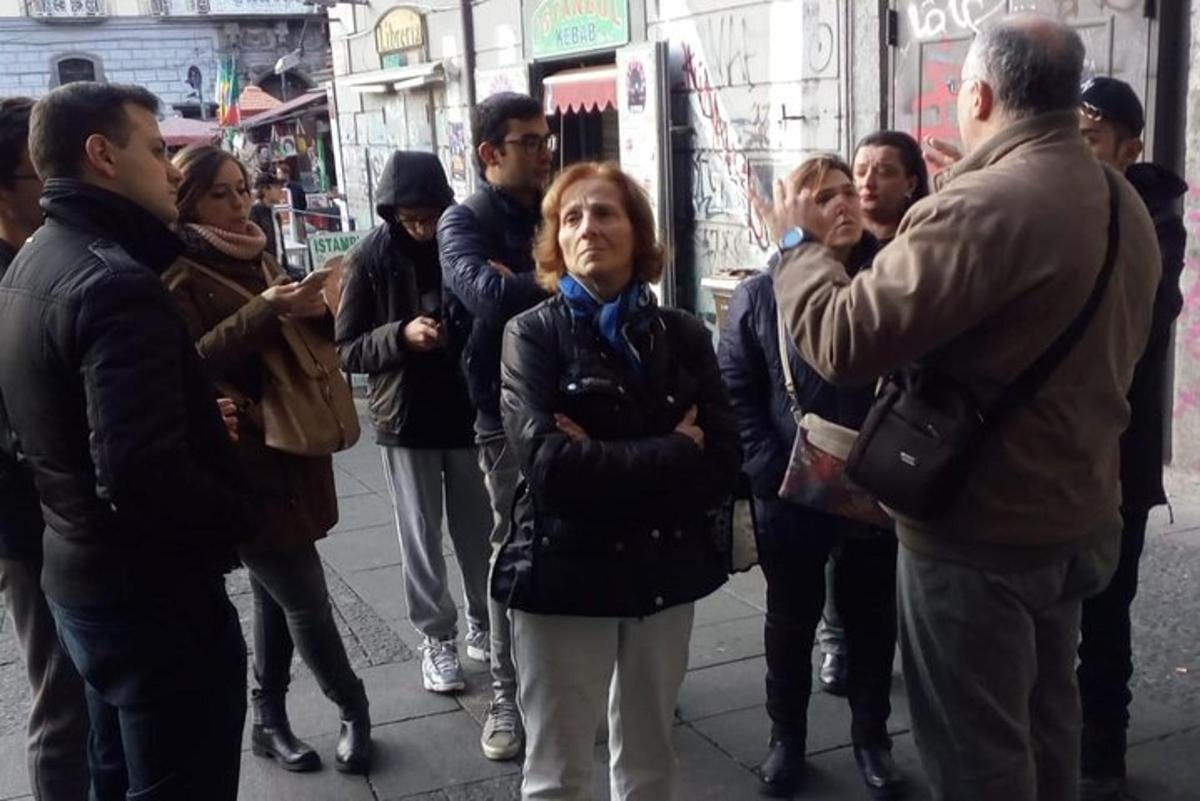 μια ομάδα ανθρώπων που στέκονται σε έναν δρόμο της πόλης