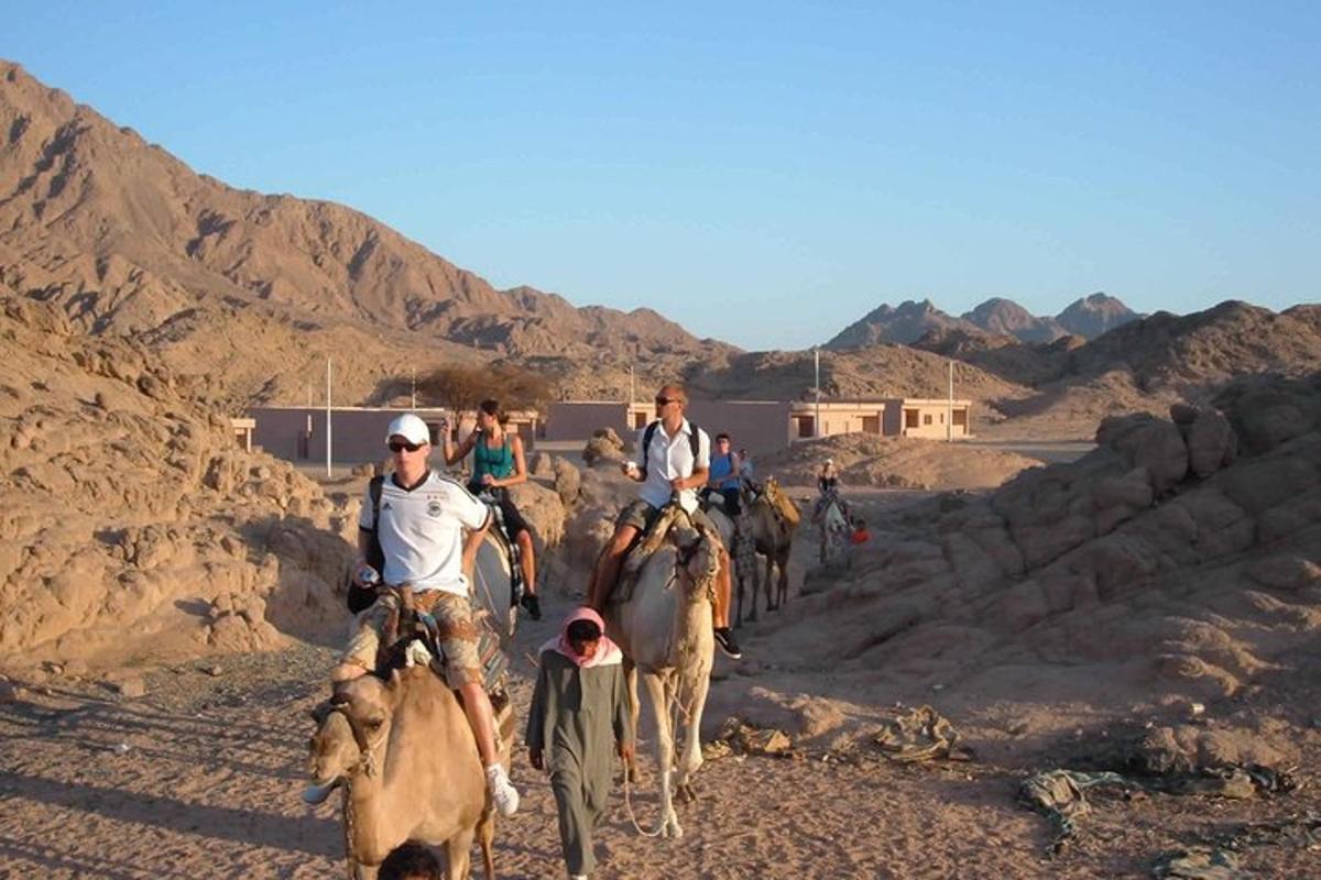 a group of people riding horses in the desert