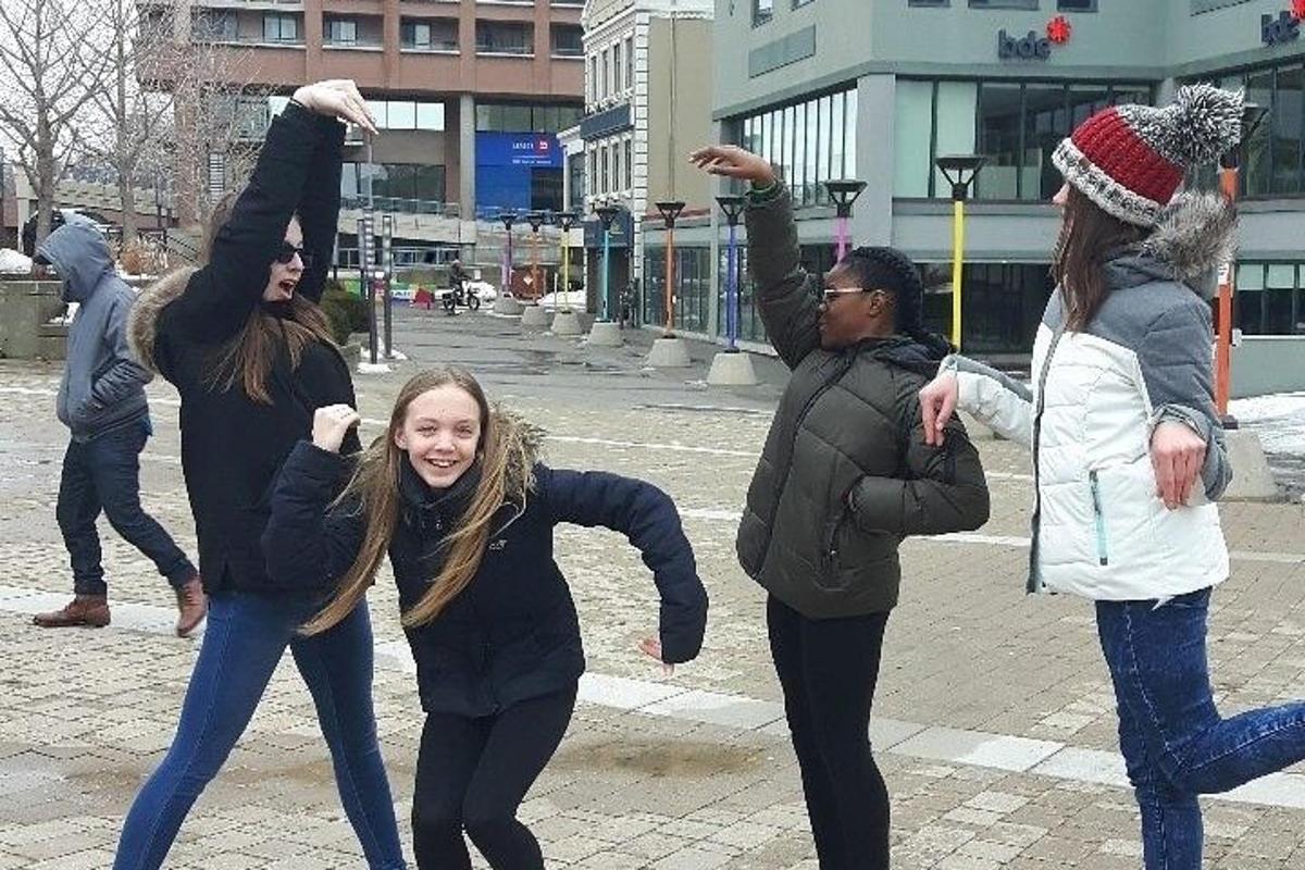 a group of women dancing on a city street