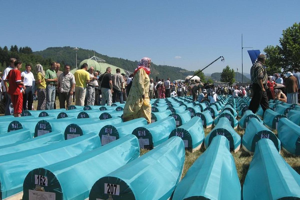 dav lidí stojících kolem řad modrých sedadel
